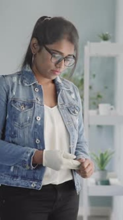 Woman Putting on White Medical Protective Glove