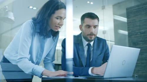 Business Colleagues Discussing Project at Desk in Office