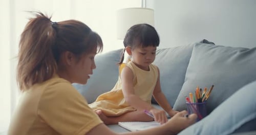 Mother and Child Drawing Together on Couch