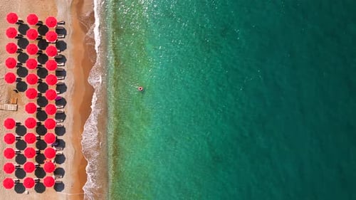 Topdown View of Sandy Beach with Sun Umbrellas and Turquoise Sea Water