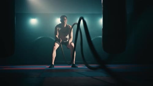 Man Does Battle Rope Exercise at the Gym