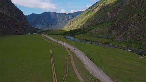 Mountain Road and Car Against the Backdrop of a Mountain Landscape in Summer