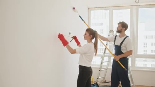 Woman and Man Painting Interior Wall Together