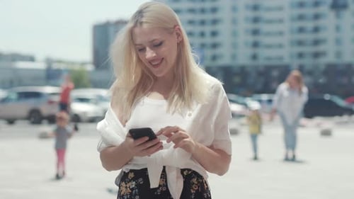 Young Woman Using Mobile Phone in Urban Setting