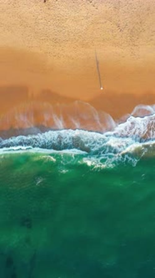 Aerial Drone of Scenic Sea Waves on Sandy Coastline During Sunny Day
