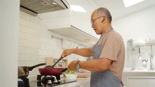 Senior Man Cooking in Bright Kitchen