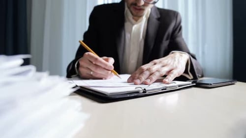 The engineer works with paper documentation in the office. Calculation and planning of drawings.