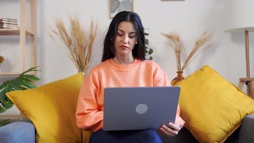 Woman Using Laptop at Home on Couch