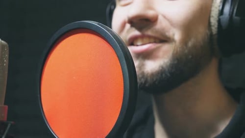 Unrecognizable Male Singer in Headphones Singing Song at Sound Studio Young Man Emotionally