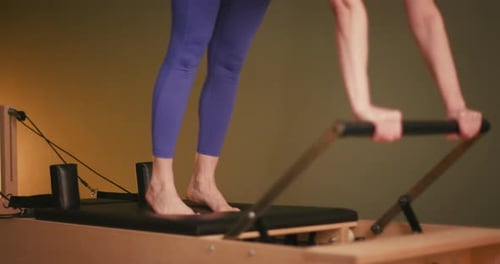 Woman Exercises on Pilates Machine for Fitness