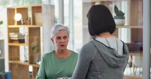 Mature Woman Lifts Dumbbells with Trainer at Home