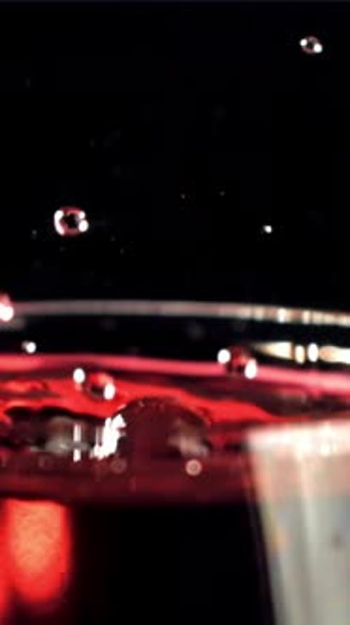 A Drop Falls Into a Glass of Wine On a Black Background Filmed on a Highspeed Camera at 1000 Fps