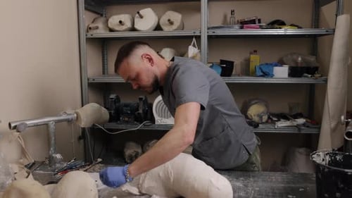 Man Crafting Plaster Orthopedic Form in Medical Workshop