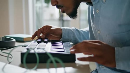 Anonymous african american dj creating electronic music at home studio