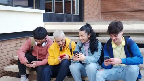 Students Smiling while Using Smartphones on Steps