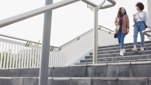 Two Young Women Walk Down Outdoor Urban Steps