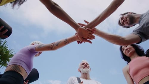 Joyful Yoga Practitioners Join Hands Under Blue Sky Bottom View