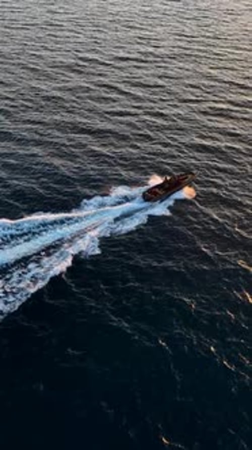 Speedboat Gliding Across Sea During Sunset Aerial View