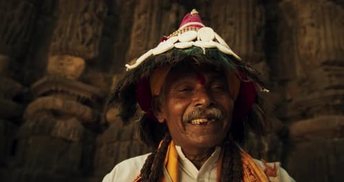 Close Up Portrait of an Old Indian Man in Traditional Attire Playing Instruments and Chanting