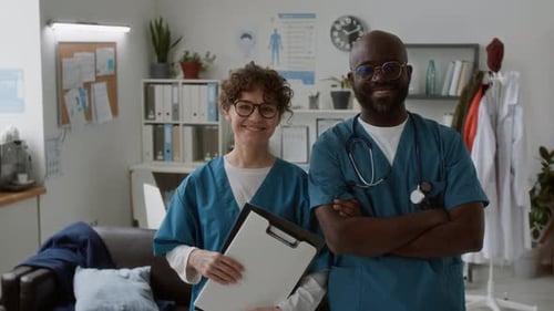 Happy Young Clinicians of Modern Hospital in Blue Uniform Looking at Camera