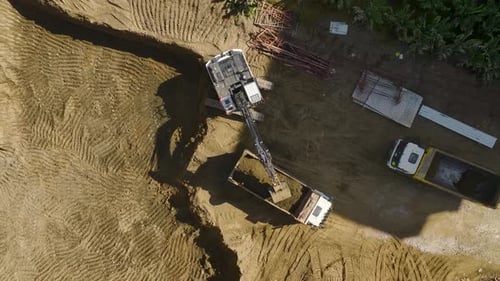 Earth Mover Aerial View of Excavator Loading Soil Into Trucks