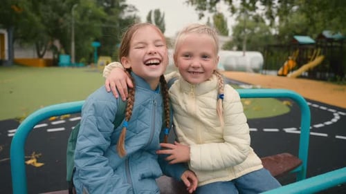 Two Little Girls Friends Sisters Riding Swing Laughing Smiling Joy Happiness Childhood Playground