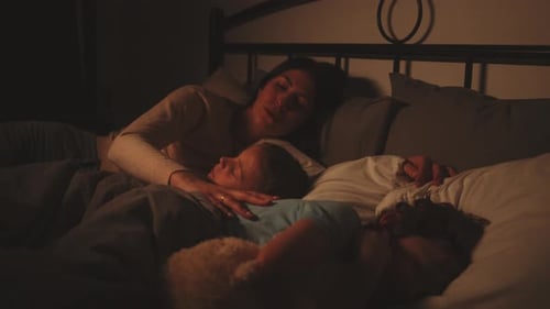 Mother Lying in Bed with Two Sleeping Children