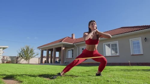 Athletic Woman Exercising with Resistance Band Outdoors