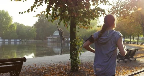 4k video footage of a young woman enjoying a park run while listening to music