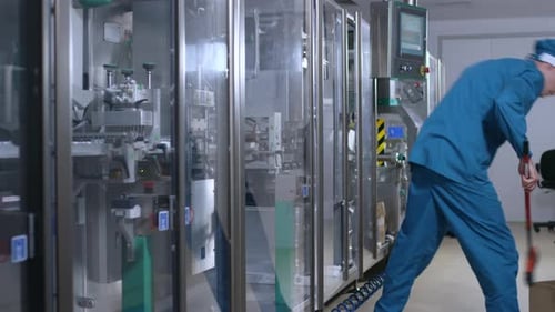 Factory Worker Sweep the Floor. Factory Operator Man Sweeping Floor Near Manufacturing