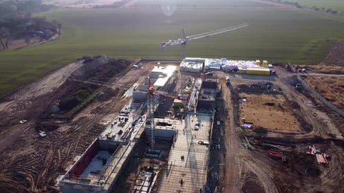 Droneflies around construction site and captures view include preparation of base of the building at