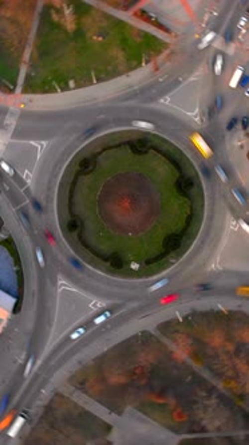 Vertical Aerial View of Roundabout Road with Circular Cars in Small European City at Summer Day