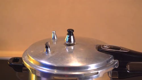 Pressure cooker with steam coming out of spinning valve