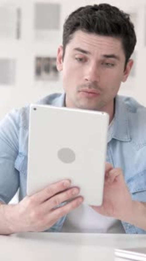 Man with Tablet Expressing Surprise and Excitement