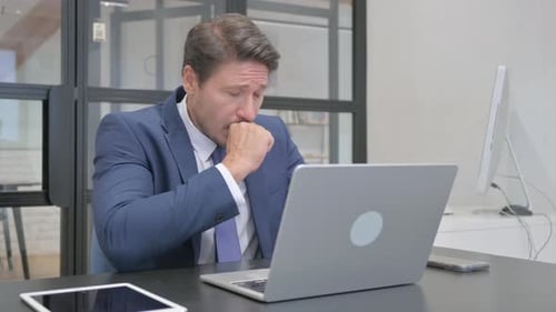 Sick Mature Adult Businessman Working in Office, Coughing