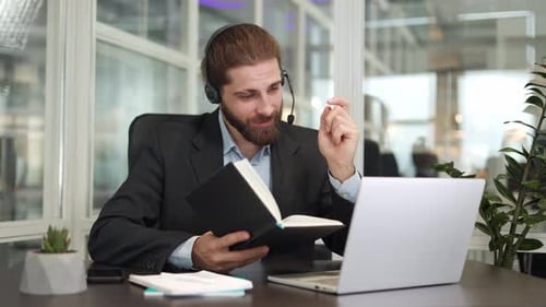 Man Talking Online Wearing Headset In Office