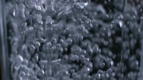 Water Poured into a Clear Glass with Bubbles