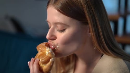 Woman Eating Cream Filled Pastry Dessert Close Up