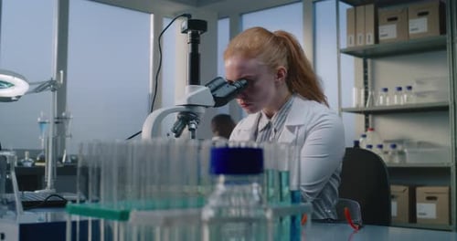 Woman Scientist Using Microscope in Modern Laboratory
