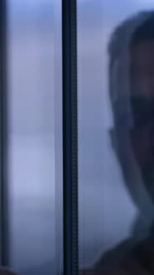 Man Looking Out Window at Night