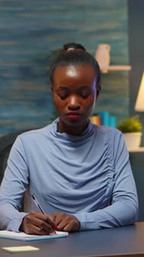 Woman Writing at Desk in Evening