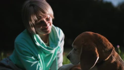 Graceful Woman Shaking Paw of Loyal Beagle Dog Under Sunset on Lush Meadow