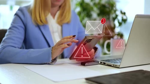 Young businesswoman using a smartphone, receiving dangerous messages with warning signs representing