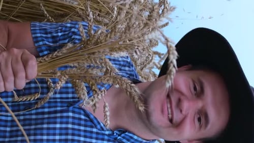 Man Holding Wheat Smiling in Country Field
