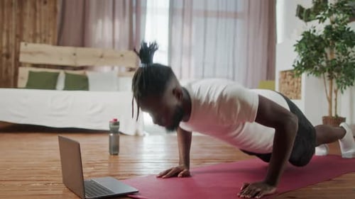 Muscular Man Doing Pushups at Home on Mat