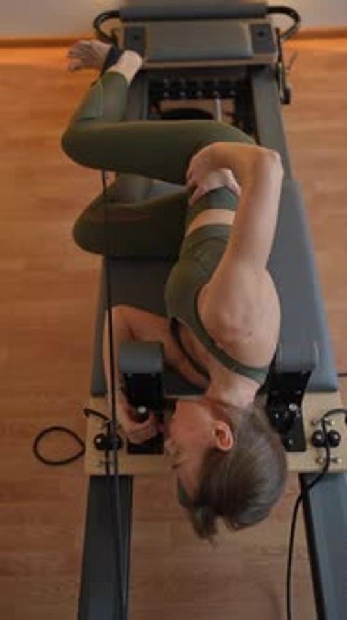 Woman Training on the Reformer Bed for Buttocks and Thighs Pilates Workout Reformer Pilates Studio
