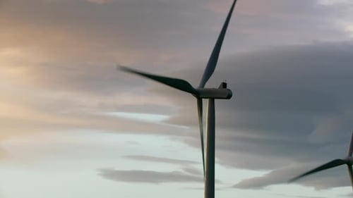 Wind Turbines Spinning at Colorful Sunrise or Sunset