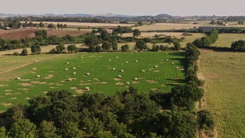 Aerial View of Hay Bales in patchy green field