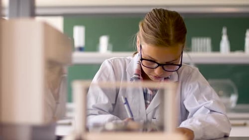 Children in Science Class Writing with Teacher Supervising