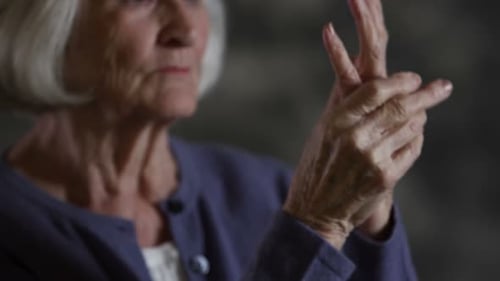 Senior Woman Massaging Sore Hand for Pain Relief